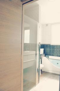奥斯坦德Villa Maredan的浴室设有通往浴缸的玻璃门