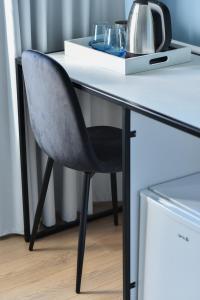 斯库台Atelier Boutique Hotel的一张黑椅,坐在一张桌子上,上面有白色的桌子