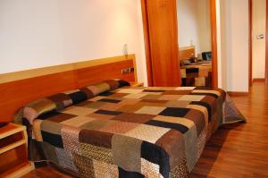 桑亨霍加莱克酒店的一间卧室配有一张床,床上有条毯子