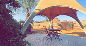 欧拉Unique Farm Cottage的沙漠帐篷下的桌椅