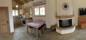 Saint-GeorgeThe Guesthouse的厨房配有桌子、电视和壁炉。