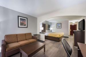 亨茨维尔Quality Inn & Suites Huntsville Research Park Area的酒店客房,配有床和沙发