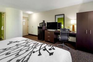 格兰德岛Sleep Inn By Choice Hotels的酒店客房配有一张床、一张书桌和一台电脑