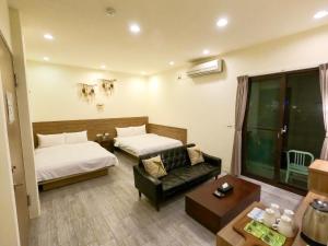 马公澎湖夏日南風民宿的酒店客房,设有两张床和一张沙发