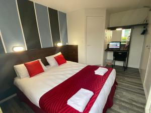 Parçay-Meslay北图尔法斯特酒店的一间卧室配有一张带红色和白色枕头的大床