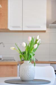 布拉采Apartman Mare Blace的白色花瓶,桌子上放着白色花