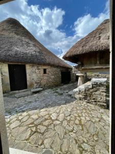 PiornedoCasa Casoa的两座大型石头建筑,拥有茅草屋顶和天空