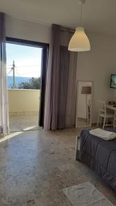 马里内拉Bahari Beachfront Aparthotel Selinunte的一间卧室设有一张床和一个大窗户