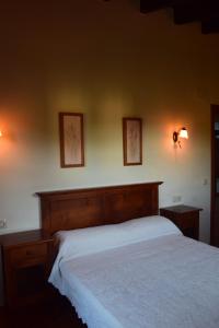 里瓦德塞利亚Amaicha Apartamentos Rurales的卧室内的一张床铺,墙上有两张照片