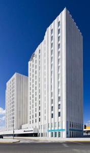 梅里那德奥拉菲YIT塞维利亚迈雷纳大街酒店的蓝色天空的高大的白色建筑