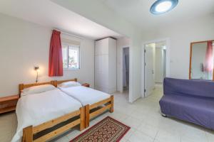 Mizra‘Mizra Guest House的一间卧室配有一张大床和一张蓝色的沙发