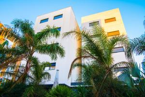 阿尔么丽亚阿尔梅利亚16:9套房公寓酒店的一座白色的建筑,前面有棕榈树