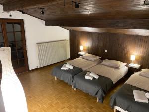 SondernachCHALET DE MANU的一间卧室设有两张床和木墙