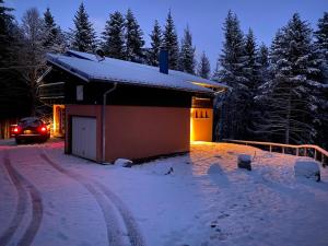 SondernachCHALET DE MANU的停在雪地的建筑物前面的汽车