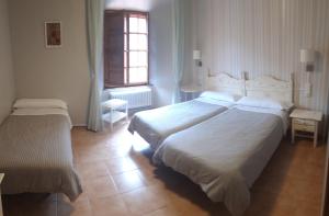 AnguianoMONASTERIO de SANTA MARÍA DE VALVANERA的酒店客房设有两张床和窗户。