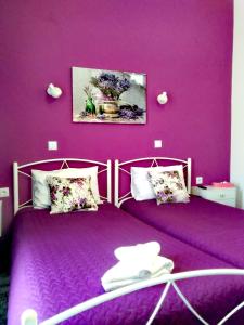斯卡拉卡伦尼斯Nancy Rooms的紫色墙壁客房的两张床