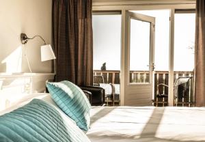 东弗利兰Loods Hotel Vlieland的一间卧室设有一张床,享有阳台的景色