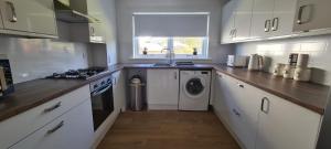 巴洛赫Craiglynn Holiday Apartment Loch Lomond的厨房配有洗衣机、洗衣机和烘干机。