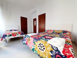 科尔多瓦Arc House Ribera Only Adults的一间卧室配有两张带彩色毯子的床