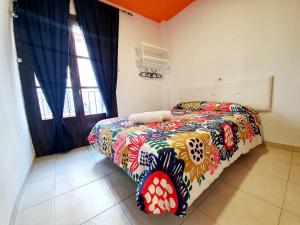 科尔多瓦Arc House Ribera Only Adults的一间卧室配有一张带彩色毯子的床