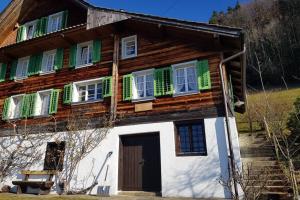 韦吉斯Bauernhaus mit Charme, Traumaussicht und Sauna的一座带绿色百叶窗和门的木制房子