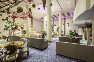 泰布克Mena Hotel Tabuk的大堂设有桌椅和鲜花