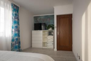 耶莱尼亚古拉ApartsW241的一间卧室配有一张床、一台电视和一扇门