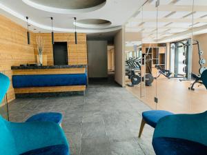 维哥迪法萨Ciampedie Luxury Alpine Spa Hotel的健身房,配有蓝色椅子和健身房