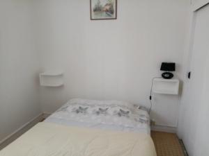 莱昂le Moustic的一间白色的小房间,里面设有一张床