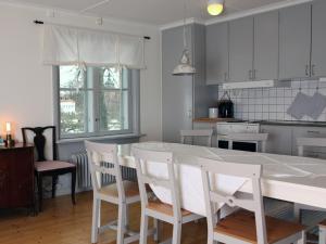 玛丽费莱德Gripsholms BnB的厨房配有白色的桌椅