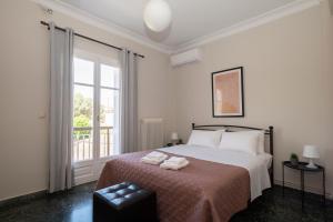 皮洛斯Navarino Apartment的白色的卧室设有床和窗户
