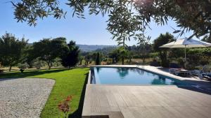 维塞乌Quinta das Regueiras的一个带遮阳伞的庭院内的游泳池