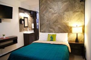 卡波圣卢卡斯Cabo Tortuga Hotel Boutique的一间卧室配有一张带绿色棉被的床