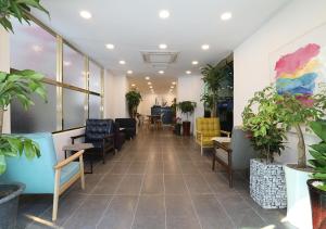 庆州Maison Mini Hotel的一间设有桌椅和植物的等候室