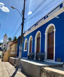 皮拉尼亚斯Pousada Ô de Casa的蓝色的建筑,在街上有两长椅