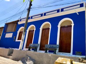 皮拉尼亚斯Pousada Ô de Casa的前面有两长椅的蓝色建筑
