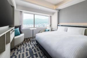 神户remm plus Kobe Sannomiya的酒店客房设有床和窗户。