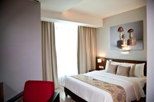 吉隆坡UTM Hotel & Residence的酒店客房,配有一张床和一张红色椅子
