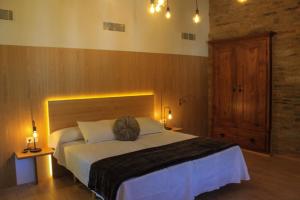 萨莫斯A Casa da Botica的一间卧室配有一张大床和木制床头板