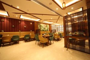 瑞诗凯诗The Vilana Hotel Rishikesh的一间带桌椅的餐厅和一间酒吧