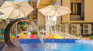 达戈米斯Отель Колизей的一个带两把遮阳伞和泳池景的游泳池