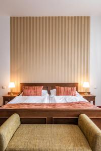克罗梅日什Hotel U Zlatého kohouta的一间卧室配有一张大床和两把椅子