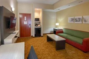 斯普林代尔Sleep Inn & Suites Springdale West的酒店客房设有绿色的沙发和桌子。