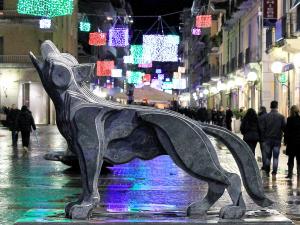 科森扎科森沙假日酒店的夜间街道上狗的雕像