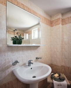 拉加纳斯Nemesis Aparthotel的一间带水槽和镜子的浴室