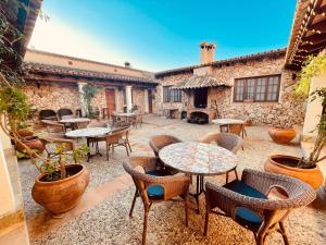 科斯提克斯Agroturismo Ses Illes的一座带桌椅的庭院和一座石头建筑