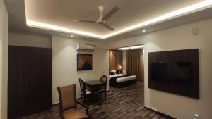 瑞诗凯诗The Vilana Hotel Rishikesh的客厅配有平面电视和沙发。