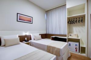 贝廷Go Inn Betim - MG的酒店客房配有两张床和一张书桌