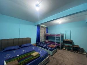 昆达桑Kupi-Kupi & Stay的一间卧室设有两张床和蓝色的墙壁