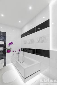 华沙Millennium La Tour的白色的浴室设有浴缸和卫生间。